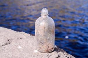 Glass bottle on the shore photo