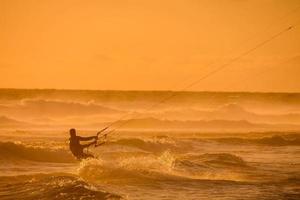 kitesurfer a puesta de sol foto