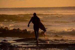 Surfer at sunset photo