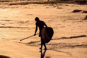 Paddle surfer at sunset photo