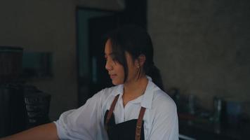 un asiático mujer bailando muy felizmente en un cocina mientras trabajando video