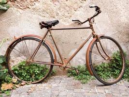 Rusty old bicycle by the wall photo