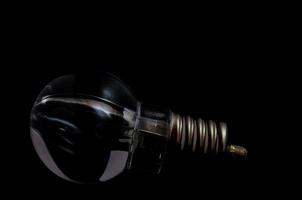 Lightbulb on on dark background photo