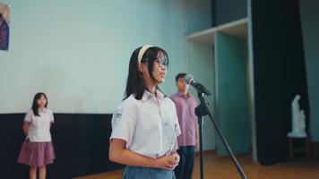 une haute école étudiant récite une poème dans de face de le juges tandis que participant dans une compétition video