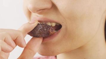 Woman eating fresh dates in close-up. Dry fruits. Close-up woman eats fresh dried dates. video