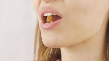 Close-up of woman eating almonds. Woman eating almonds in close-up.