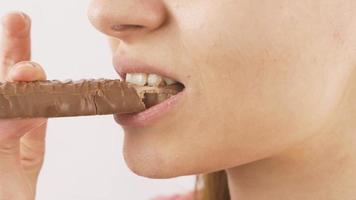 dolce cibo. avvicinamento ritratto di donna mangiare cioccolato. avvicinamento ritratto di donna mangiare cioccolato. video