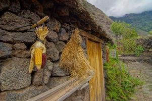 Hanging corn on the side of the stone hut photo