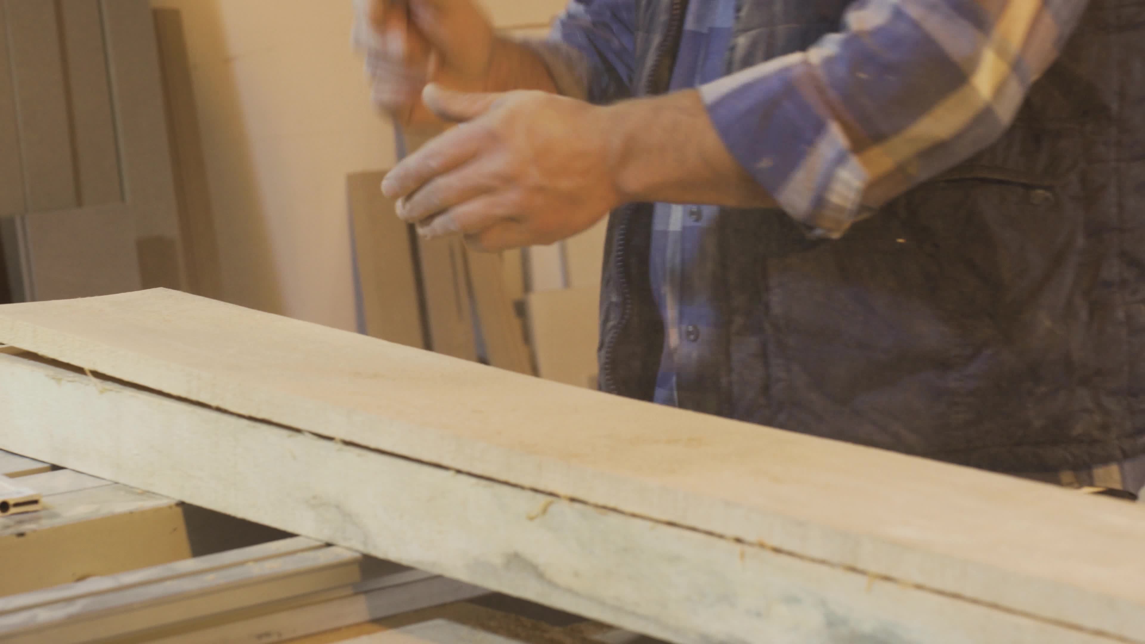 Carpenter man clapping and cleaning his dusty and sawdust hands