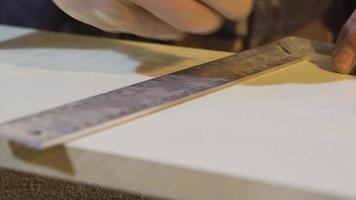 Senior carpenter hands measure a wood with a ruler in workshop. Carpenter's Hands Measures the board with a ruler and marks it with a pencil. video