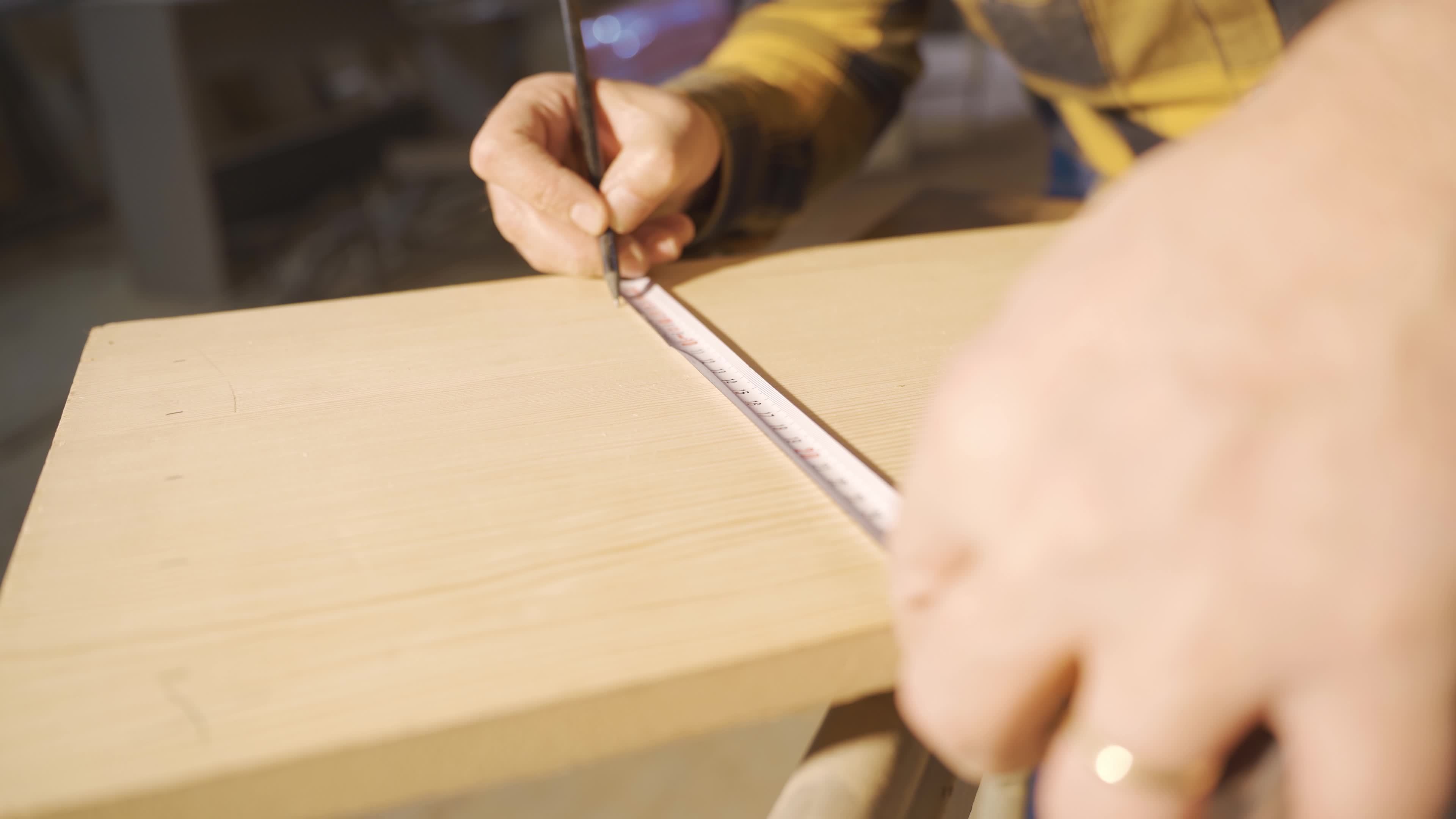 Timber measurement by meter. Male carpenter measuring wood with meter