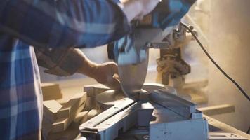 carpintero es corte madera con eléctrico circular sierra. masculino carpintero cortes madera con circular Sierra en carpintería taller.