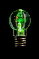 Green lightbulb on dark background photo