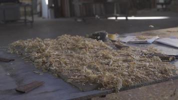 el carpintero limpia el polvo y papas fritas desde el madera. carpintero limpieza polvo en lento movimiento. video