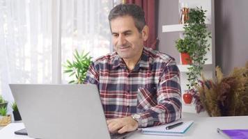 uomo d'affari Lavorando nel casa ufficio con il computer portatile. uomo d'affari Lavorando a partire dal casa Lavorando con il computer portatile e godendo esso. video