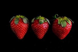 Strawberries on black background photo