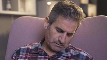 Sleep disorders. Man falls asleep on sofa at home. video