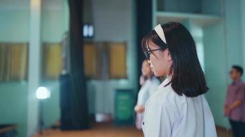 an Asian student walks in front of the microphone to do a public speaking in front of the judges video