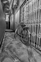 Old bicycle in black and white. Bike left at the fence on the street photo