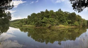 Panoramic view of a beautiful calm river with reflection. photo