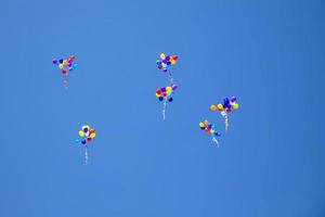 The multi colored helium balloons flying In the blue sky. the concept of a wedding, celebration, anniversary, entertainment photo