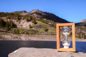 Hourglass on a rock photo