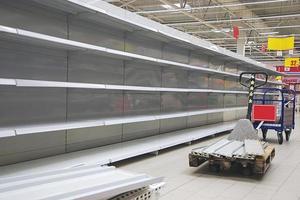 Empty shelves and cart in grocery store photo