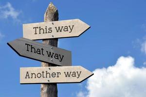 This Way, That Way, Another Way - Wooden Signpost with Three Arrows, Sky with Clouds photo