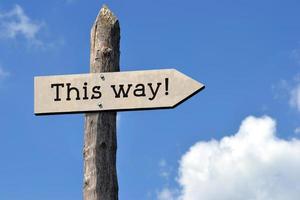 This Way - Wooden Signpost with one Arrow, Sky with Clouds photo