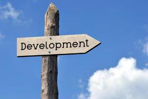 Development - Wooden Signpost with one Arrow, Sky with Clouds photo