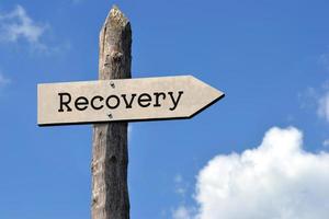 Recovery - Wooden Signpost with one Arrow, Sky with Clouds photo
