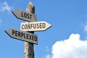 Lost, Confused, Perplexed - Wooden Signpost with Three Arrows photo