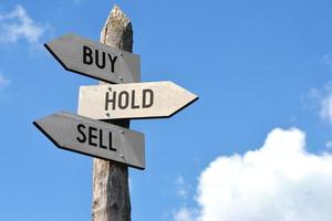 Buy, Hold, Sell - Wooden Signpost with Three Arrows photo