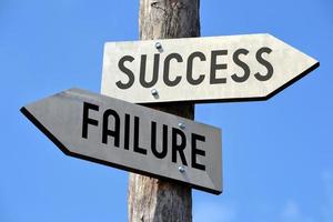 Success and Failure - Wooden Signpost with Two Arrows photo