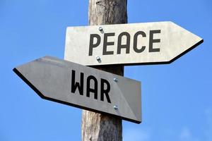 Peace and War - Wooden Signpost with Two Arrows photo