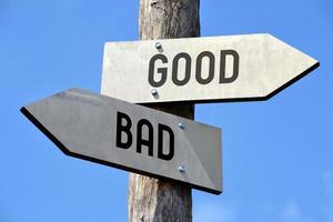 Good and Bad - Wooden Signpost with Two Arrows photo