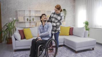 Woman and disabled man having happy time at home. Happy disabled man and his girlfriend look at camera and smile. video