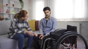 gehandicapt Mens in rolstoel en zijn vriendin praten. de meisje wie geeft Moreel en ondersteuning naar haar verdrietig gehandicapt vriend is aan het doen haar het beste. video