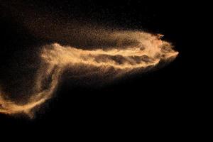 Brown colored sand splash.Dry river sand explosion isolated on black background. photo