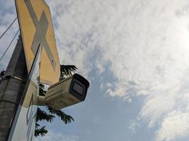 a ccty mounted on an power pole with a cloudy sky photo