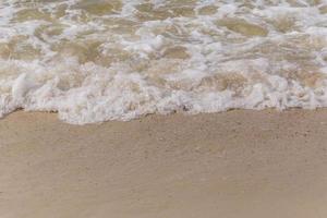 sea waves washing on sandy beach photo