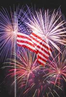 American flag on flagpole against fireworks photo