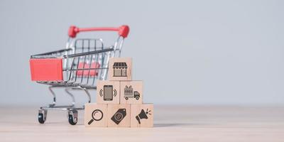 shopping cart and wooden blocks on the table ,concept Consumer society ,Shopping service on online web and offers home delivery ,online payment ,shopping on the Internet ,e-commerce