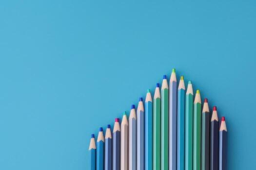 colorful pencils on plain table, top view of blue table photo