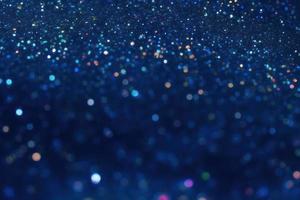 glitter particles on blue dark background, bokeh and sparkles backdrop photo