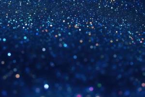 glitter particles on blue dark background, bokeh and sparkles backdrop photo