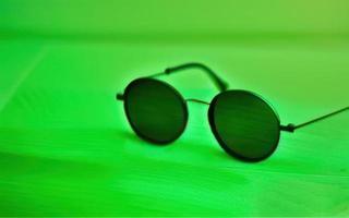 3d hacer Gafas de sol en verde fondo, gafas de protección en verde foto