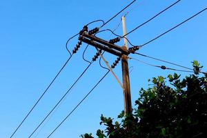 Tangled electrical wires on urban electric pole. Disorganized and messy to organization management concept. Closeup tangled electrical wires . Should take underground wire for beautiful landscape. photo