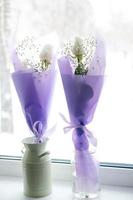 dos ramos de flores de blanco rosas en púrpura embalaje en el antepecho foto