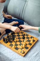 Two children are playing chess close-up. Makes a knight and pawn move photo